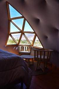- une chambre avec une grande fenêtre, un lit et une table dans l'établissement Domo La Isla, à Tilcara