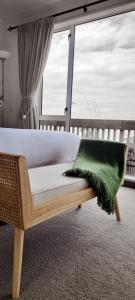 a bedroom with a bed with a green pillow on it at Kaka Point Spa Accommodation - Catlins in Kaka Point