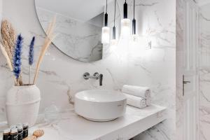 Baño blanco con lavabo y espejo en Pelagia Apartments, en Koroni