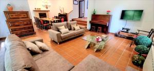 a living room with a couch and a table and a piano at Casa MATRIA in Ponteareas