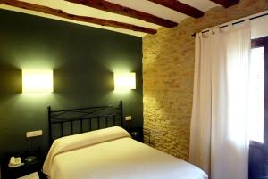 A bed or beds in a room at Hotel El Faixero Tradicional