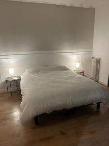 een bed in een slaapkamer met 2 tafels en 2 lampen bij Centre Maison appartement 100 m de la plage 150 m du port in Les Sables-dʼOlonne