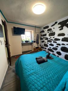 a bedroom with a blue bed with a cow wall at Los Amantes de la naturaleza. in Salão