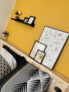 a bedroom with a yellow wall and a bed with pillows at Le Jean Bart - Lille in Lille