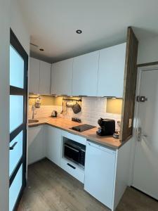 a kitchen with white cabinets and a counter top at Le Jean Bart - Lille Votre T1 meublé cosy & lumineux Quartier République in Lille +17 photos
