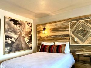 Horseshoe Bend Motel في Lovell: غرفة نوم مع سرير مع لوحة كبيرة على الحائط