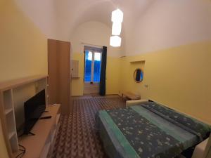 Schlafzimmer mit einem Bett und einem Flachbild-TV in der Unterkunft Sweet Home in Leverano
