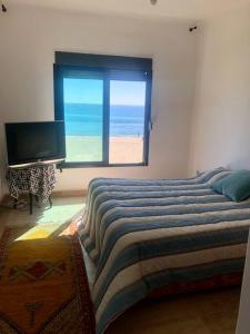 弗尼迪克的住宿－Magnifique Villa Front de Mer à Fnideq，一间卧室配有一张床,享有海滩美景