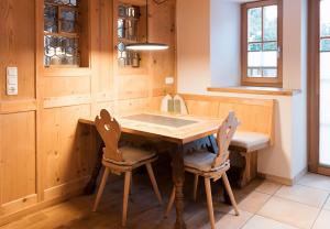 une cuisine avec une table en bois et deux chaises dans l'établissement Haus Luisa by Emju, à Schruns 271 autres photos