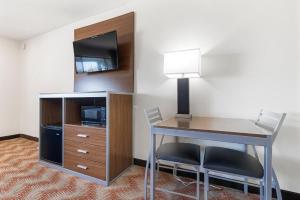 a hotel room with a desk and a tv at Heritage Inn Express Roseville in Roseville