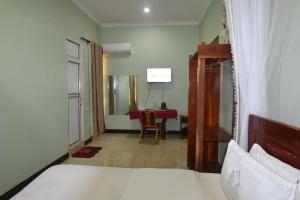 1 dormitorio con 1 cama y comedor con mesa en BETTER LIFE HOTEL KASULU, 