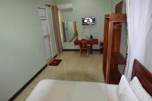 a room with a bed and a dining room with a table at BETTER LIFE HOTEL KASULU 