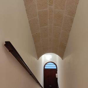 un corridoio mansardato con porta e soffitto di DIMORA STORICA ALLA ROTONDA a Mottola