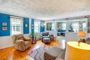 a living room with blue walls and wooden floors at Stamford Farmhouse with Deck in Catskill Foothills in Stamford