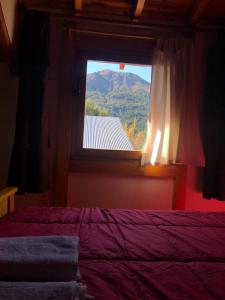 a bedroom with a window with a view of a mountain at Cabañas Ojo de Cielo in San Carlos de Bariloche