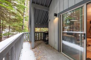 eine abgeschirmte Veranda mit einer Glastür an einem Haus in der Unterkunft Forest Trails by Outpost Whistler in Whistler