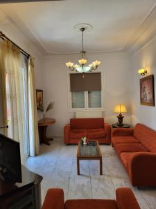 sala de estar con sofás rojos y TV en Rêve, en Zakynthos