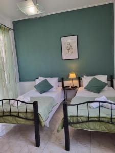 2 camas en una habitación con una pared azul en Rêve, en Zakynthos