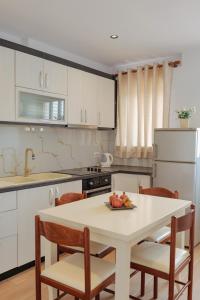 a kitchen with a table with a plate of fruit on it at Villa Abedini in Ksamil