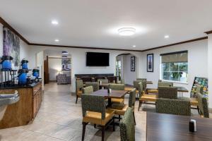 a restaurant with tables and chairs and a tv at Best Western Morgan City Inn in Morgan City