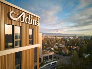 a building with a sign on the side of it at Adina Apartment Hotel Geneva in Geneva