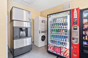 a soda machine next to a washing machine and a refrigerator at Blue Water Inn & Suites BW Signature Collection in North Topsail Beach