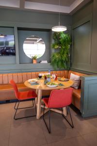 una sala da pranzo con un tavolo e sedie rosse di ibis Concepcion a Concepción