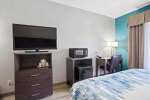 a hotel room with a bed and a flat screen tv at Blue Water Inn & Suites BW Signature Collection in North Topsail Beach