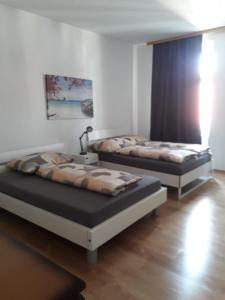 twee bedden in een kamer met houten vloeren bij Apartment Schlössel 24 in Wenen