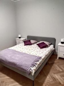 Un dormitorio con una cama con almohadas moradas. en ToTuToTam, en Varsovia