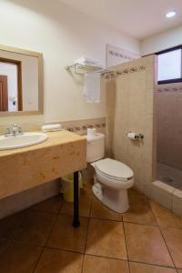 y baño con aseo, lavabo y ducha. en HOTEL COLLI en San José del Cabo