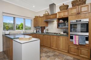 a kitchen with wooden cabinets and a white refrigerator at Gowan Ross Cottage in Mount Wilson