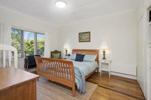 una camera con letto, scrivania e finestra di Gowan Ross Cottage a Mount Wilson