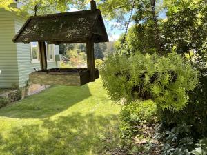 a garden with a wooden gazebo in a yard at Gowan Ross Cottage in Mount Wilson