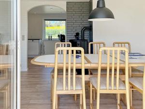 a kitchen and dining room with a table and chairs at Holiday home Østervrå II in Østervrå