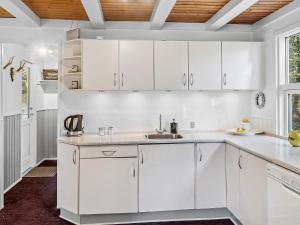 a white kitchen with white cabinets and a sink at 6 person holiday home in Bording-By Traum in Bording Stationsby +18 photos
