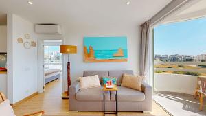 a living room with a couch and a view of the ocean at Apartamento da Avó Té - em frente à Praia c piscina in Portimão