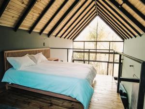 a bedroom with a bed and a large window at VOLARE Experience in Guatapé