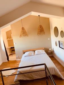ein Schlafzimmer mit einem Bett und zwei Hängelampen in der Unterkunft Superbe Ferme avec piscine in Vaison-la-Romaine