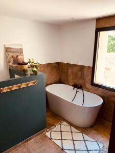 ein Bad mit einer großen Badewanne in einem Zimmer in der Unterkunft Superbe Ferme avec piscine in Vaison-la-Romaine