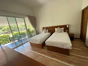 a bedroom with two beds and a balcony at Kata Forte Resort in Kata Beach
