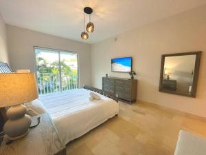 una camera da letto con un letto grande e una grande finestra di Modern Apartment - Steps to Puntarena Beach Club & Shops - Marina Overlook - Sleeps 10 a Boca de Río Hato