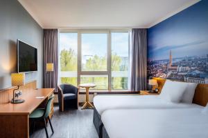 a hotel room with a bed and desk and a large window at Crowne Plaza Antwerpen, an IHG Hotel in Antwerp
