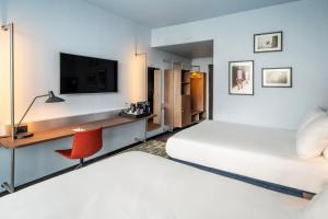 a hotel room with two beds and a desk with a tv at Crowne Plaza Antwerpen, an IHG Hotel in Antwerp