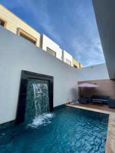 a swimming pool with a waterfall in the middle of a building at Harhoura in El Harhoura