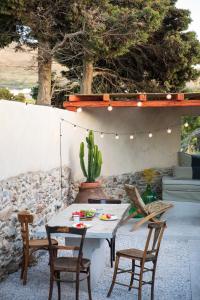 a patio with a table and chairs and a cactus at Onos Eco Living in Mési