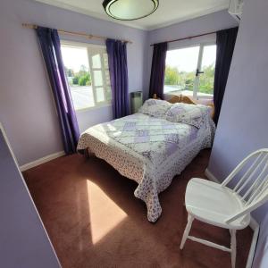 a bedroom with a bed and a chair and a window at Alquiler en la sierra in Tandil