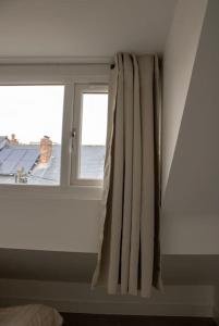 a window in a room with a curtain at Modern 4 Bed En-suite House in Leeds - Free parking in Headingley