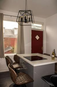 a kitchen with a counter and two bar chairs at Modern 4 Bed En-suite House in Leeds - Free parking in Headingley