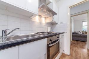 eine weiße Küche mit einer Spüle und einem Herd in der Unterkunft One bedroom flat in Central London #02 in London